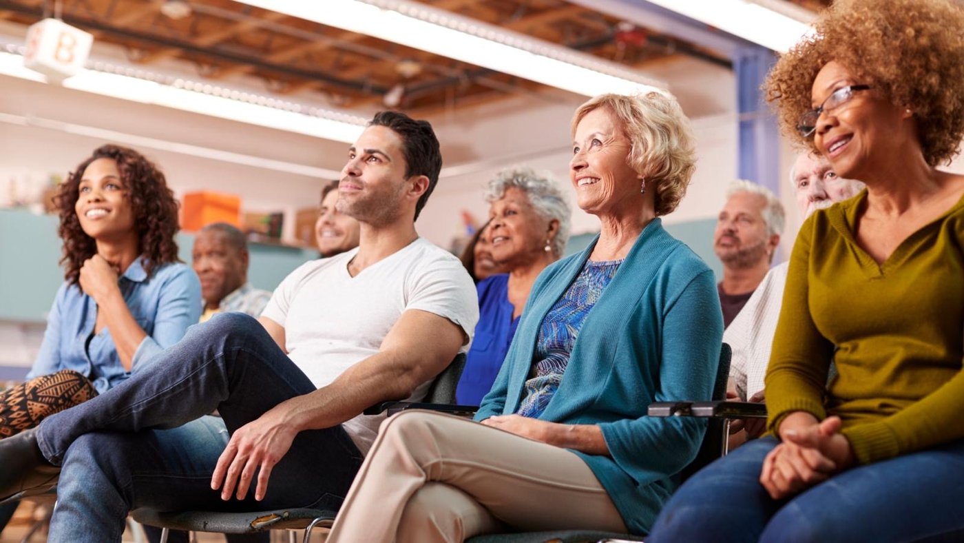 A joyful, diverse audience smiling together at the event